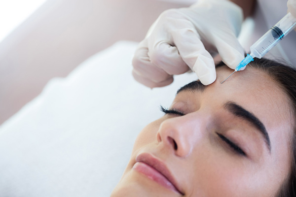 A woman receiving Botox injections from a doctor.